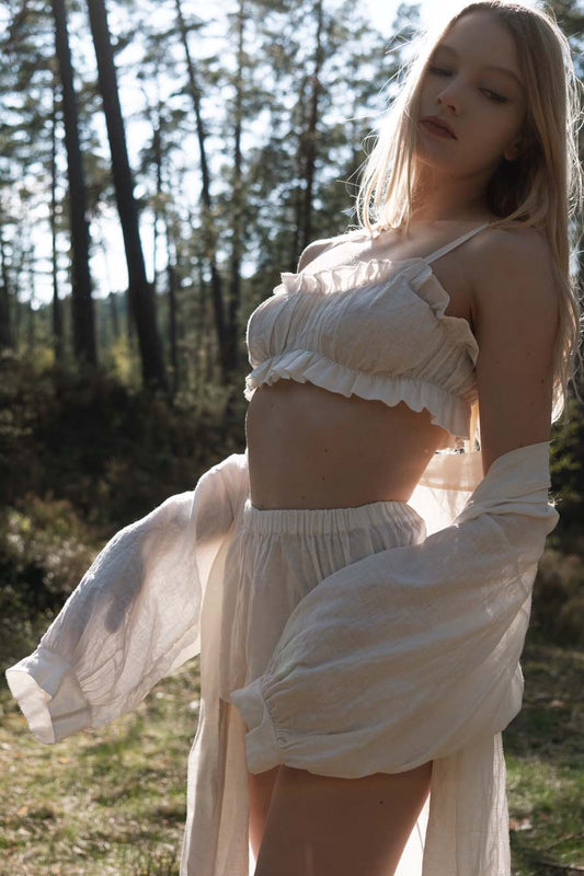 Organic, sustainable and sexy at the same time! Agasåga set of a white cute bralette with frills, little shorts with high waist and an oversized coat/robe dress with fluffy 3/4 sleeves. These garments are natural, soft, breathable and pure. It’s a conscious and healthy choice for your body and environment that embraces genuine selflove and selfcare. Handmade with love in the North.