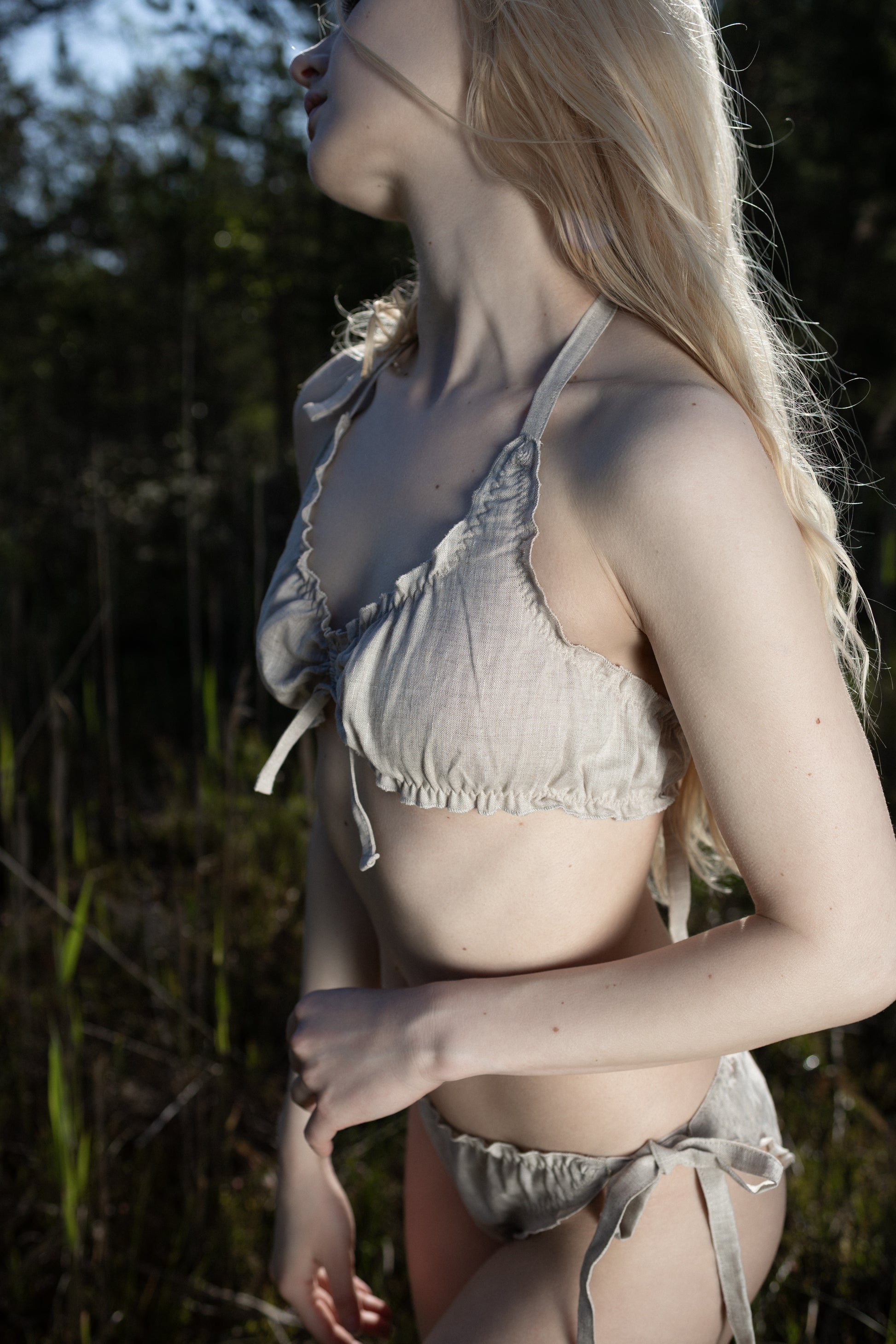 Model wearing natural beige organic linen bikini top and bottoms, eco-friendly swimwear.